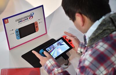 A visitor plays a Nintendo's new Switch game console during its game experience session in Tokyo on January 14, 2017. 
Nintendo on January 13 unveiled its new Switch game console, which works both at home and on-the-go, as it looks to offset disappointing Wii U sales and go head to head with rival Sony's hugely popular PlayStation 4. / AFP PHOTO / KAZUHIRO NOGI