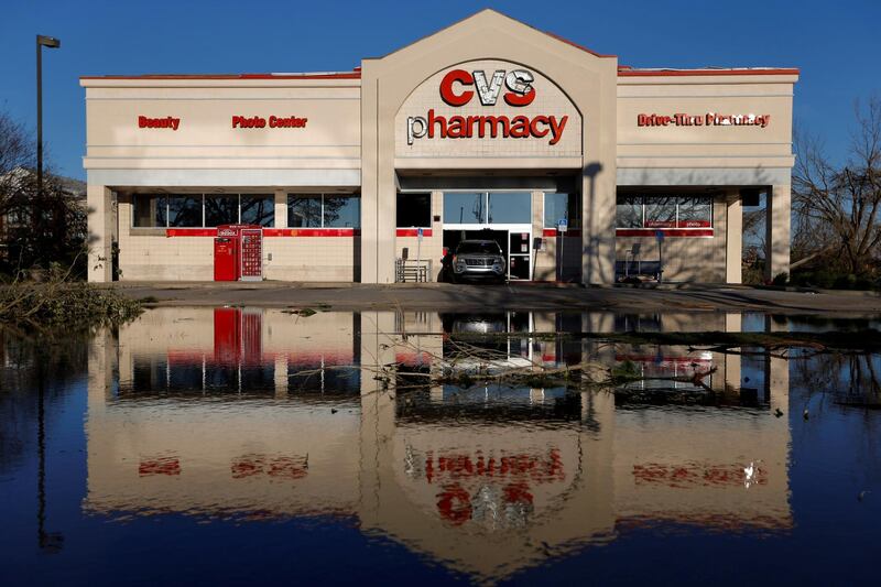 A law enforcement officer guards a pharmacy damaged by Hurricane Michael in Callaway, Florida. Reuters