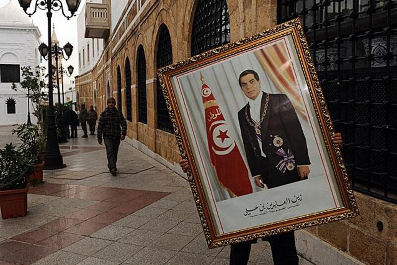 An employee of the Tunisian Prime Ministry removes the portrait of toppled the toppled president, Zine El Abidine Ben Ali, on January 17.