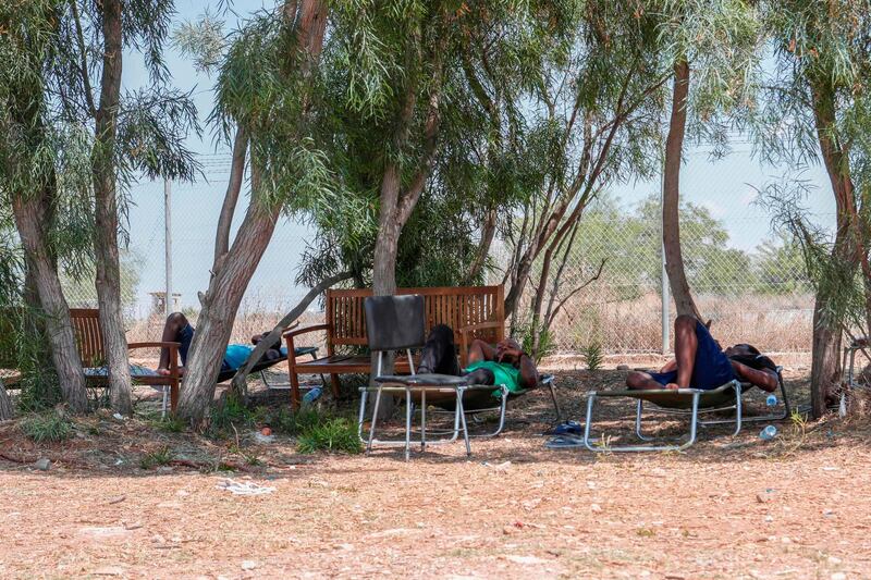 African migrants lie in the shade at Pournara camp. AFP