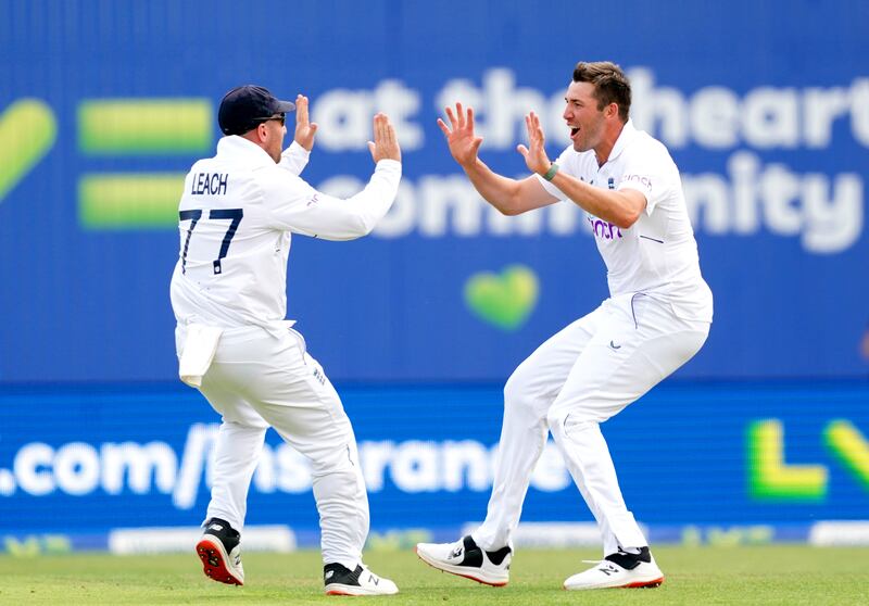 Jamie Overton, right, celebrates with England teammate Jack Leach after taking the wicket of New Zealand's Devon Conway. It was the bowler's first in Test cricket. PA
