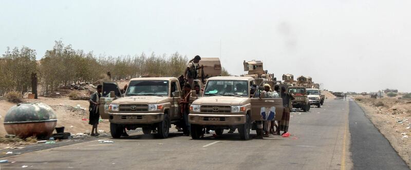 Yemeni fighters from the Amalqa ("Giants") Brigades, loyal to the Saudi-backed government, gather with armed pick-up trucks and armoured vehicles on the side of a road during the offensive to seize the Red Sea port city of Hodeidah from Iran-backed Houthi rebels, on its southern outskirts near the airport on June 21, 2018. Saleh Al-Obeidi / AFP