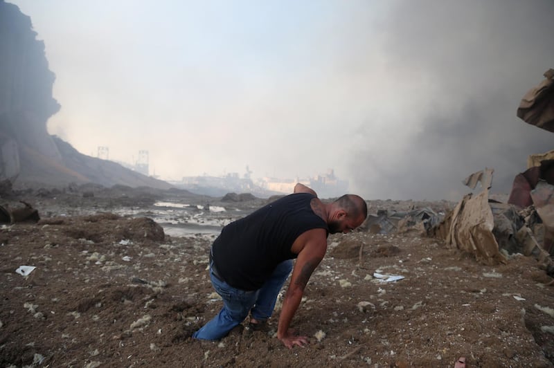 A man tries to walk in the mud near the scene of explosion at the Beirut port.  EPA