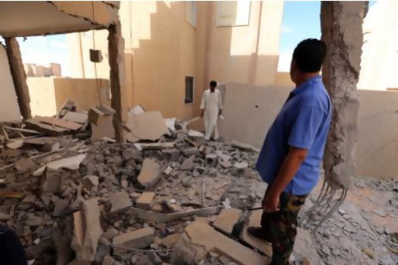 Libyan men inspect a destroyed building in Bani Walid, almost 200 kilometres southeast of Tripoli.
