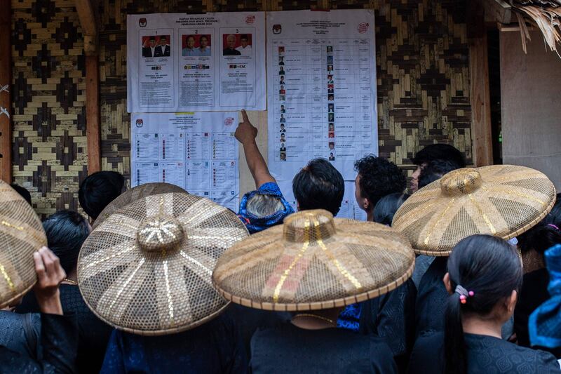 Members of the indigenous Baduy tribe check candidates before voting in Indonesia’s elections in Kanekes Village, Banten province. AFP