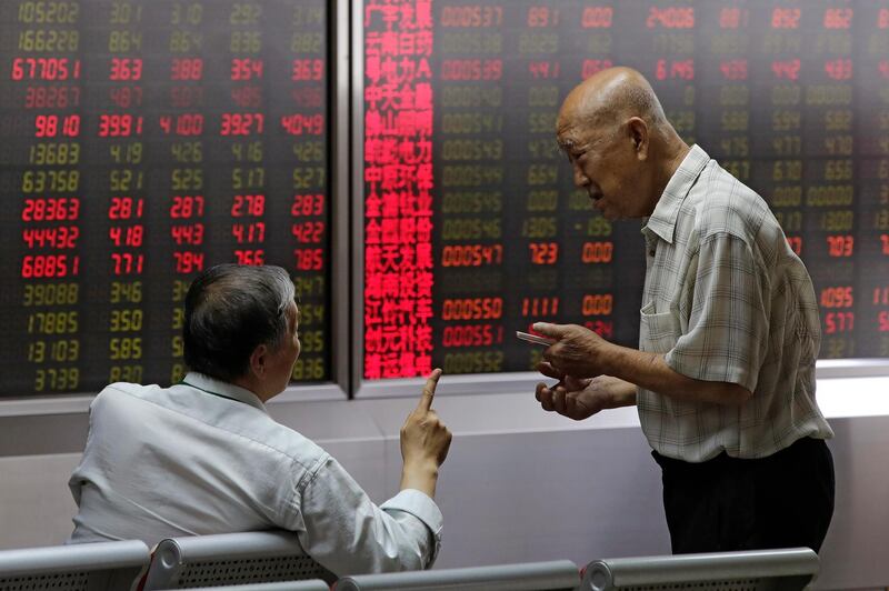 People chat as they monitor stock prices at a brokerage house in Beijing, Thursday, Aug. 16, 2018. Asian shares are falling as investors fret over slowing economic growth, especially in China. Technology stocks and oil and metals prices skidded overnight on Wall Street. (AP Photo/Andy Wong)