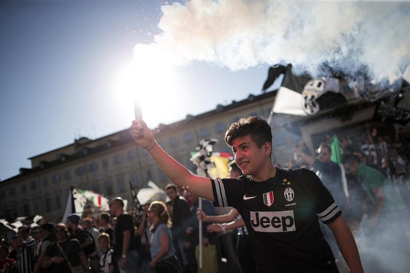 A Juventus supporter lights a flare as he celebrates his football club's Serie A title on Sunday. Marco Bertorello / AFP / May 4, 2014