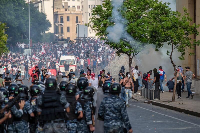 Lebanese security forces watch protesters trying to enter the parliament building during clashes with Lebanese riot police at a mass protest against the economic and financial crisis, and to demand early parliamentary elections, in Beirut, Lebanon.  EPA