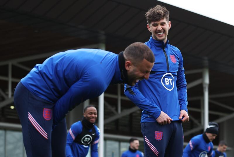 BURTON UPON TRENT, ENGLAND - MARCH 23: John Stones of England shares a joke with teammate Kyle Walker during a training session ahead of an upcoming FIFA World Cup Qatar 2022 Euro Qualifier against San Marino at St George's Park on March 23, 2021 in Burton upon Trent, England. (Photo by Eddie Keogh - The FA/The FA via Getty Images)