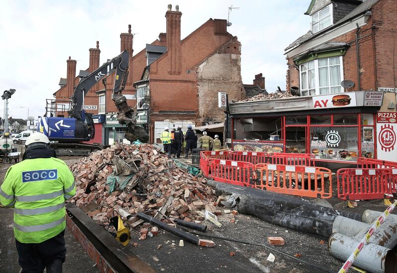 Emergency services at the scene in Leicester, Tuesday Feb. 27, 2018, where emergency services are still searching for victims after an explosion which destroyed a building on Sunday. British police said Wednesday Feb. 28, 2018, they have arrested three men in connection with the explosion that killed five people. (Aaron Chown/PA via AP)
