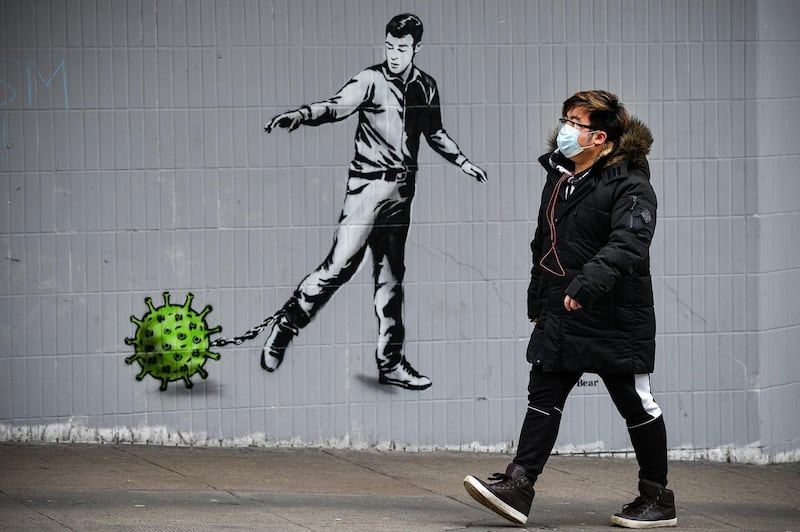 A man walks past a coronavirus mural on a building in Bath Street in Glasgow, Scotland. Getty Images
