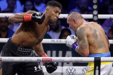 Ukraine's Oleksandr Usyk (R) and Britain's Anthony Joshua (L) compete during the heavyweight boxing rematch for the WBA, WBO, IBO and IBF titles, at the King Abdullah Sports City Arena in the Saudi Red Sea city of Jeddah, on August 20, 2022. - Usyk won his rematch against Anthony Joshua by split decision to retain his world heavyweight titles in just his fourth fight in the division in Saudi Arabia late tonight. (Photo by Giuseppe CACACE  /  AFP) (Photo by GIUSEPPE CACACE / AFP via Getty Images)