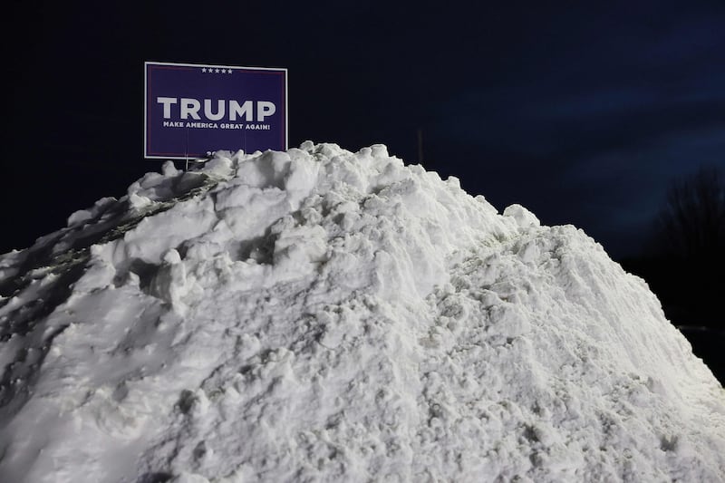 A Trump campaign sign in a snow mound outside the caucus site in Clive. AFP