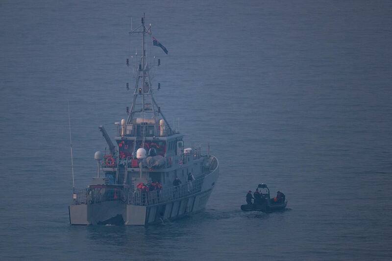 A UK Border Force vessel sails in front of a boat carrying migrants. Getty