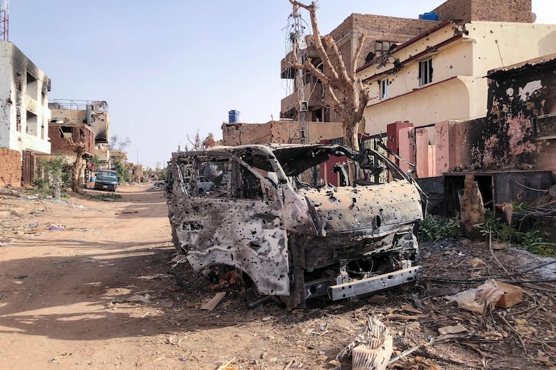 A burnt-out vehicle in front of damaged buildings in Omdurman, central Sudan. AFP