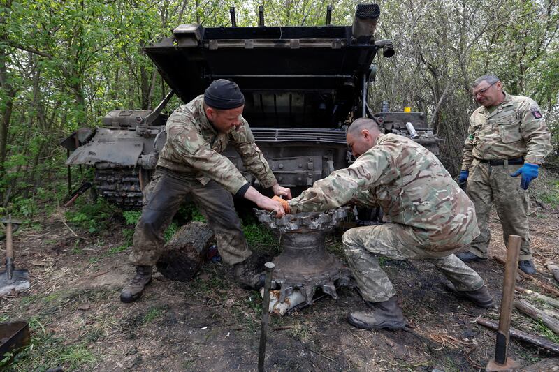 Ukrainian servicemen repair a tank in the Kharkiv region of northeastern Ukraine. Reuters