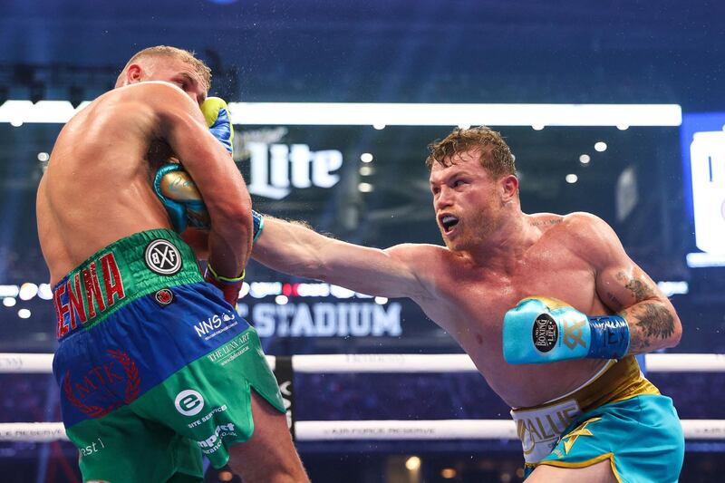 Saul Alvarez lands a body shot on Billy Joe Saunders during their super middleweight title fight at the AT&T Stadium. AFP