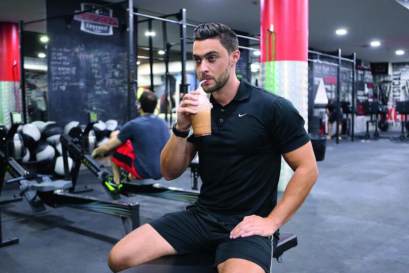 Dan Woolley of Target Fitness, Dubai, drinks a protein shake to restore energy after a workout. Pawan Singh / The National