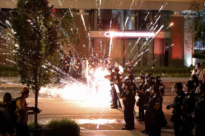 A firework explodes by a police line as demonstrators gather to protest the death of George Floyd, Saturday, May 30, 2020, near the White House in Washington. Floyd died after being restrained by Minneapolis police officers. (AP Photo/Alex Brandon)