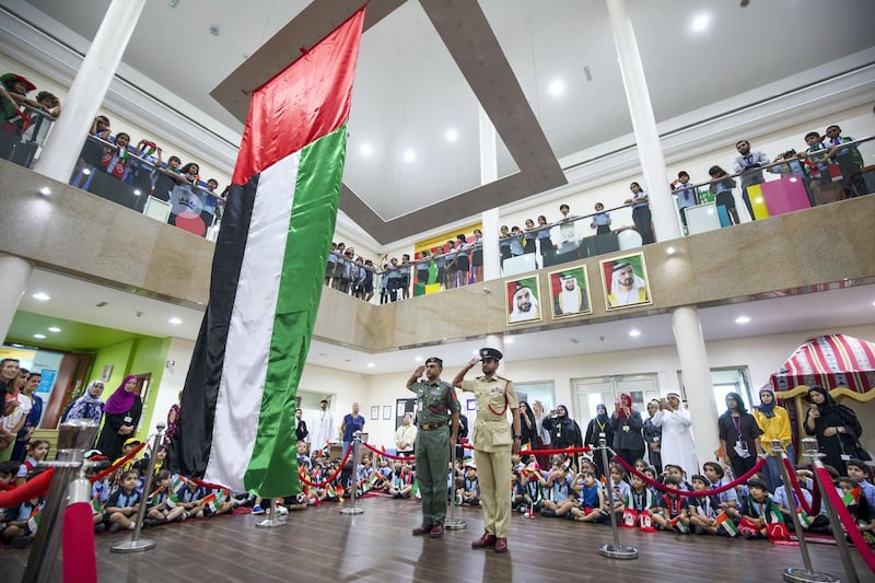DUBAI, UNITED ARAB EMIRATES - Abdullah Ali Almansoori and Humaid Mohammed Alnuaimi saluting the flag with the students from Gems Royal Dubai School celebrating UAE flag day.  Leslie Pableo for The National fro Anam Rizvi’s story