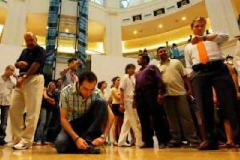 Dubai, 26th August 2008.  Firas Natouv (tying the shoe lace) and Jordan Baker (looking at his watch), as throngs of spectators were amazed, during a flash mob, held at the Mall of the Emirates.  (Jeffrey E. Biteng / The National) *** Local Caption ***  JB0775-FMob.jpg
