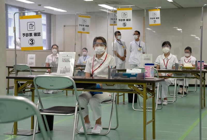 Nurses wait to process people arriving to receive the Moderna coronavirus disease (COVID-19) vaccine at the newly-opened mass vaccination centre in Tokyo, Japan, May 24, 2021.  Carl Court/Pool via REUTERS