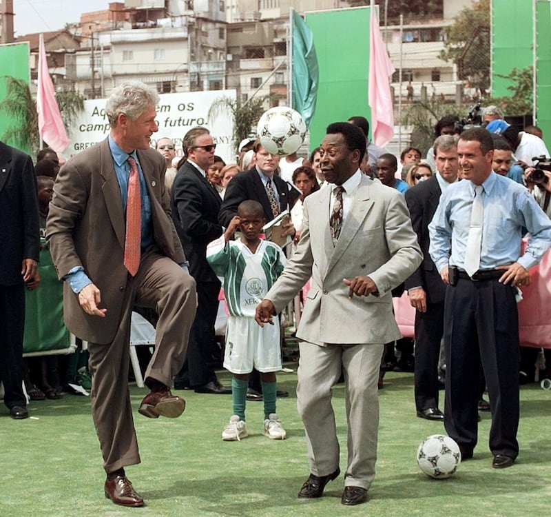 Bill Clinton, US president at the time, plays with Pele, in October 1997, during a visit to the Mangueira School in the favela of the same name, in Rio de Janeiro. AFP