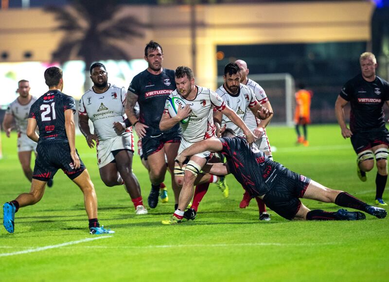 Chris Mackee  tries to drive through Dubai Exiles defence during their match at Zayed Sports City rugby fields.