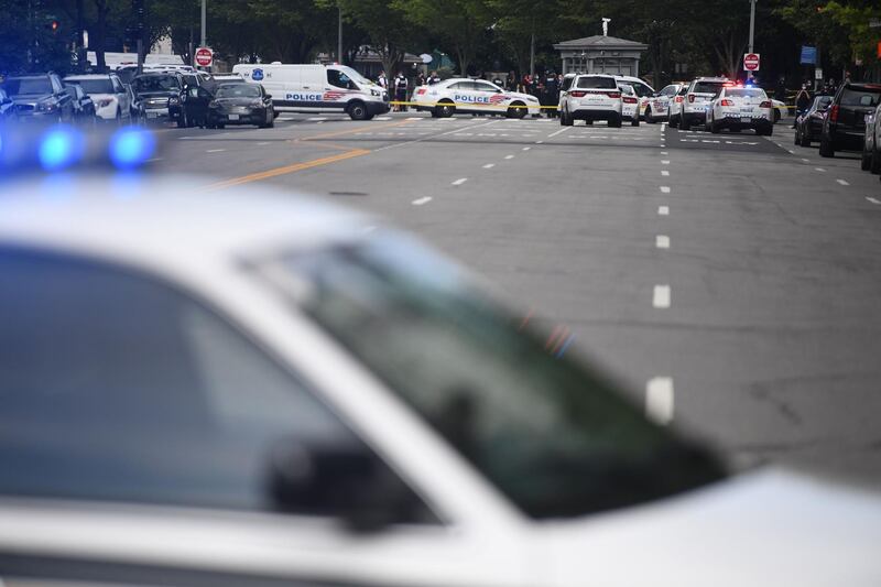 Police cars block the entrance to Pennsylvania Avenue near the White House shortly after Secret Service guards shot a person who was apparently armed, outside the White House.
  AFP