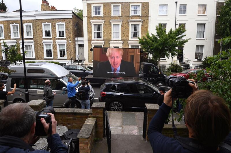 Political campaign group Led By Donkeys transport a screen showing a pre-recorded video link of Britain's Boris Johnson delivering a statement, outside the home of his senior aide Dominic Cummings, in London. AP