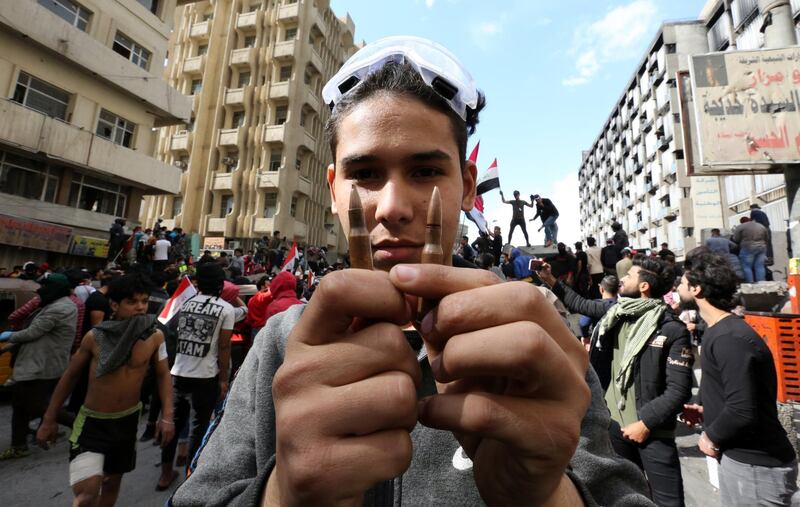 An Iraqi protester holds live ammunition which was allegedly used by security forces during clashes with protesters at the Al-Khilani square in central Baghdad, Iraq.  EPA