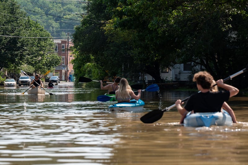 People kayak up and down the flooded waters of Elm Street in Montpelier, Vermont. AFP