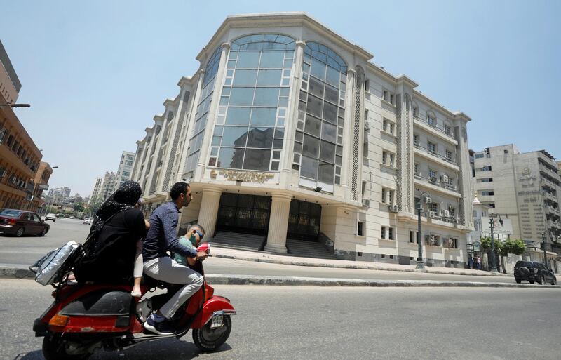 A family rides a motorbike in front of National Hepatology and Tropical Medicine Research Institute amid concerns about the spread of the coronavirus disease (COVID-19), in Cairo, in Egypt May 26, 2020. Picture taken May 26, 2020. REUTERS/Staff
