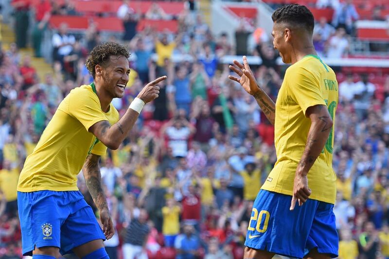 Brazil's striker Roberto Firmino (R) celebrates with Brazil's striker Neymar after scoring their second goal during the International friendly football match between Brazil and Croatia at Anfield in Liverpool on June 3, 2018. Brazil won the game 2-0. / AFP / Oli SCARFF                          
