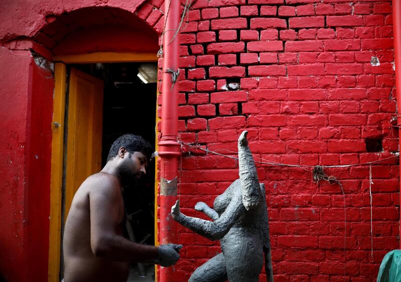 epa07930511 An Indian clay artist works on an unfinished idol of the Goddess Kali ahead of the Diwali festival at Kumartuly district in Kolkata, eastern India,18 October 2019. Kali, the Goddess of Power, is worshiped during the Hindu festival.  EPA