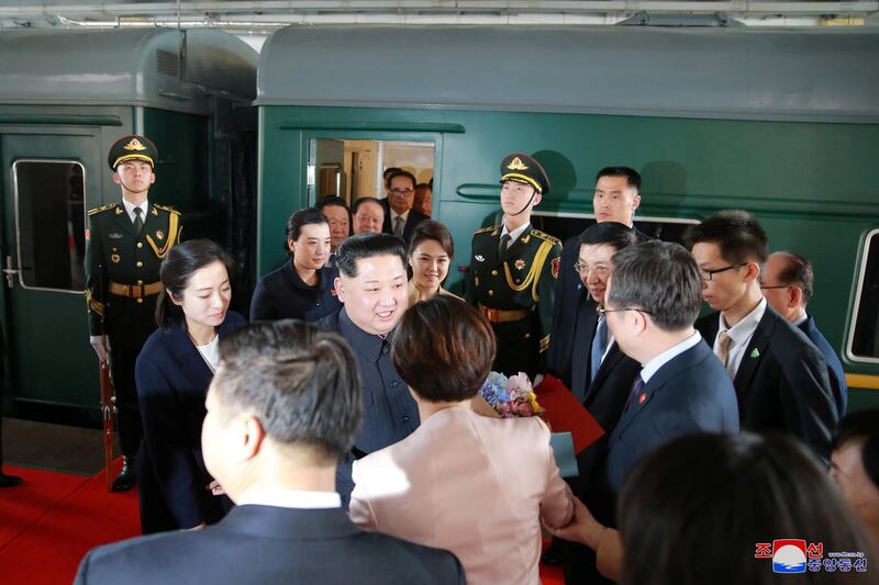 North Korean leader Kim Jong Un and his wife Ri Sol Ju are seen near a train as he paid an unofficial visit to China. KCNA / via Reuters