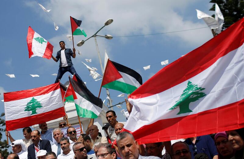 People hold Palestinian and Lebanese flags as they gather to show solidarity with the Lebanese people following Tuesday's blast in Beirut's port area, in Gaza City. REUTERS