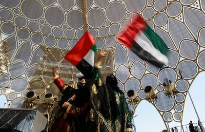 Emirati women wave UAE flags during the celebration of the 50th UAE National Day at Expo 2020 Dubai. EPA 