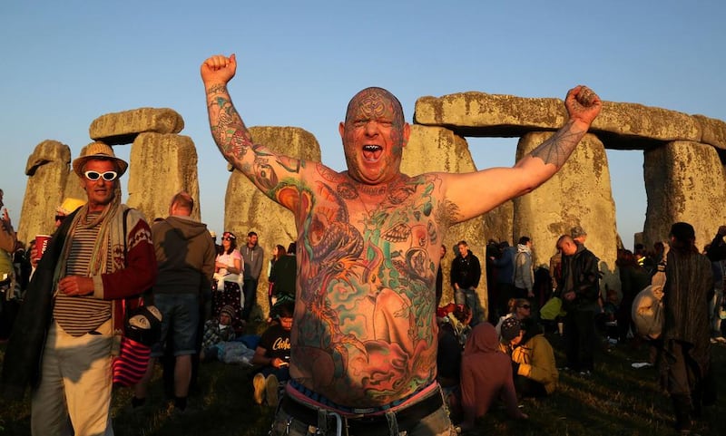 A reveller called Mad Alan (real name) celebrates the 2014 summer solstice at sunrise at the prehistoric monument Stonehenge. Geoff Caddick / AFP photo