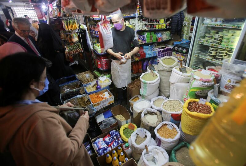 A vendor wearing a protective face mask serves customers inside his shop, ahead of the Muslim holy month of Ramadan, amid concerns over the coronavirus disease (COVID-19), in Algiers, Algeria. REUTERS