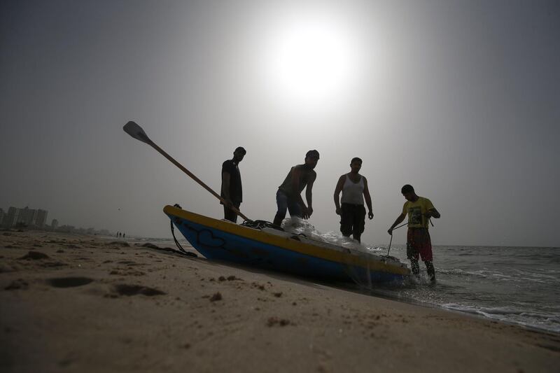 Palestinian fishermen prepare their nets during sunset along a beach in Gaza City. AFP