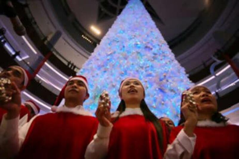 Shoppers play in front of the 29-metre tall Christmas tree at Dubai Mall.