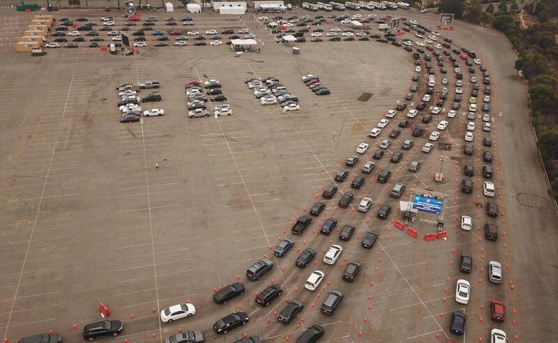 This aerial view shows people waiting in line in their cars at a Covid-19 testing site at Dodger Stadium in Los Angeles.  AFP