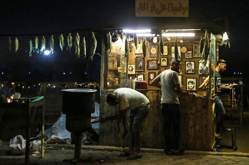 A Palestinian sells corn cobs and hot drinks at a stall along a promenade by a beach in Gaza City.  AFP