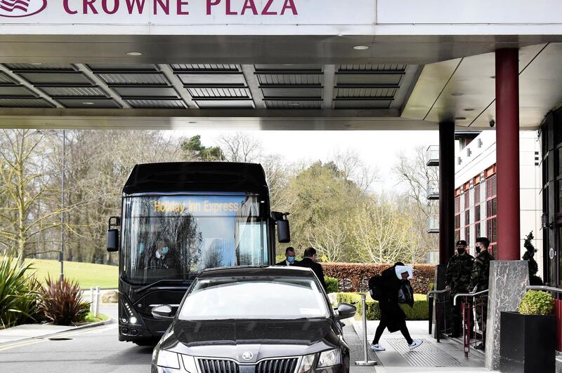 A passenger covers her face after getting off a designated quarantine bus at Crowne Plaza Dublin Airport Hotel, as Ireland introduces hotel quarantine programme for 'high-risk' countries' travellers, in Dublin, Ireland March 26, 2021. REUTERS/Clodagh Kilcoyne