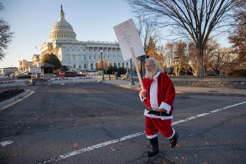 A man dressed as Santa Claus holds an impeachment protest sign outside the US Capitol in Washington, DC, USA, 18 December 2019.  EPA