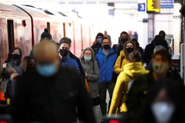 People wear masks on a train platform at Waterloo Station in London. Reuters