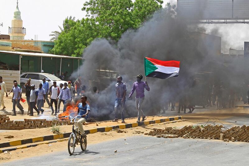 Obscured by smoke, protesters march. AFP