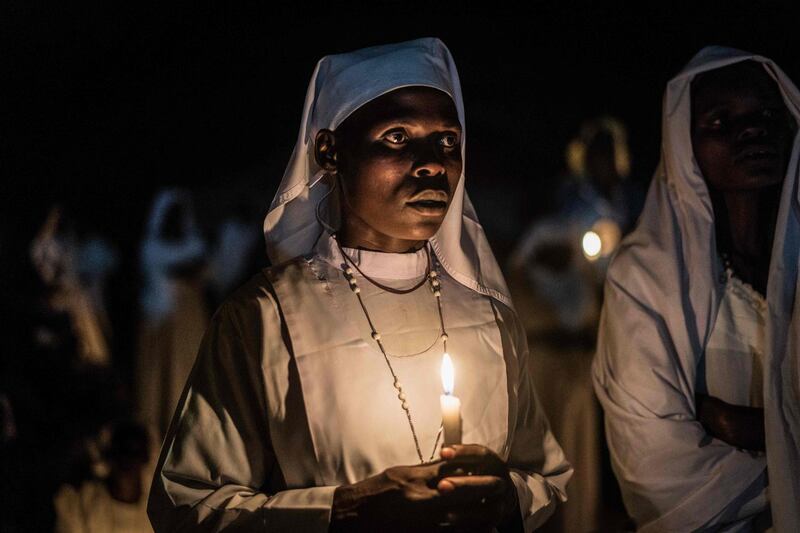 Believers of Legio Maria of African Church Mission hold candles during their overnight Christmas Mass at the church near Ugunja, the western part of Kenya. Fredrik Lerneryd / AFP Photo.