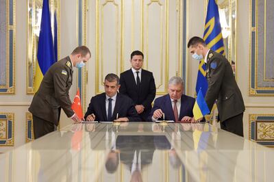 Ukraine's President Volodymyr Zelenskiy looks on while Defence Minister Andriy Taran and CEO of the Turkish defence technology company Baykar Haluk Bayraktar sign a memorandum to establish joint training and maintenance centres for Turkish armed drones in Kiev. Reuters